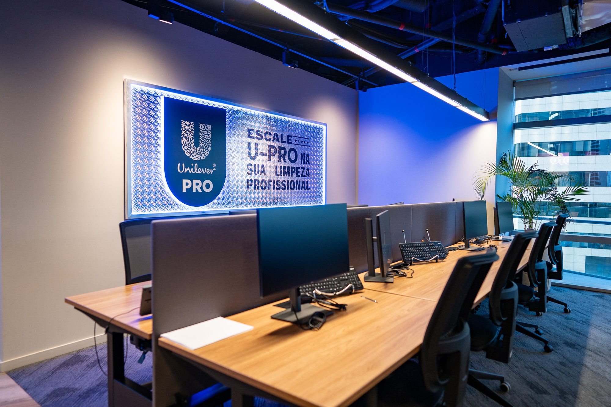 Estações de trabalho da Unilever, com identidade Unilever PRO na parede